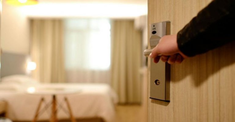 Hotels - Person Holding on Door Lever Inside Room