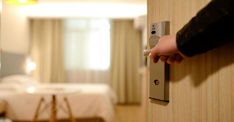 Hotels - Person Holding on Door Lever Inside Room